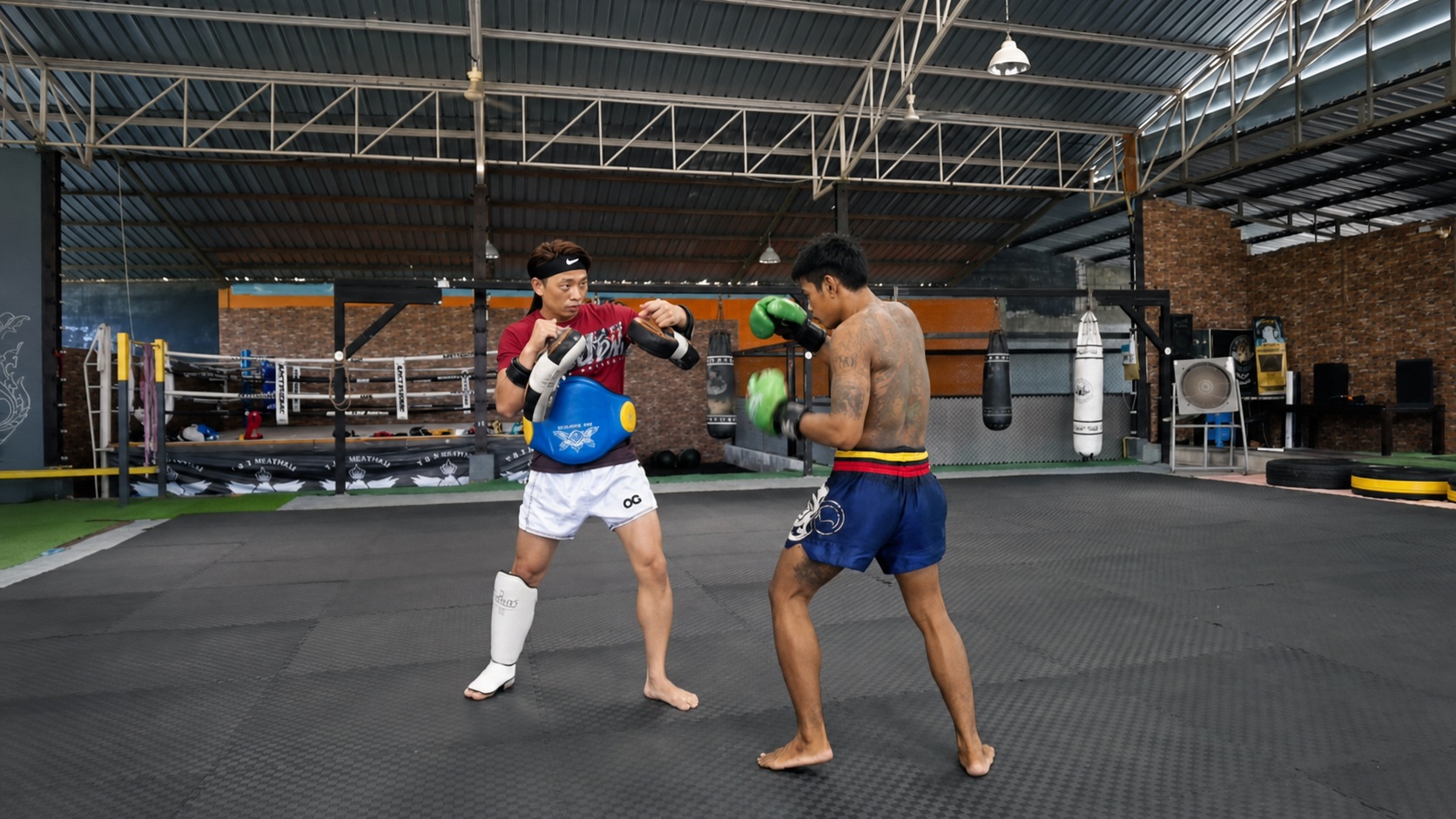 Coach Ben working on pad timing during training in Thailand